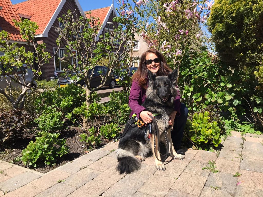 Annemiek zit geknield bij Yoko in haar tuin