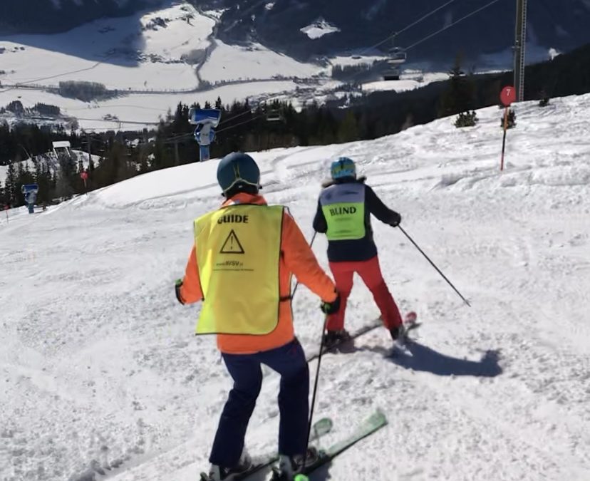 Annemiek skiënd, begeleid door een NVSV-begeleider