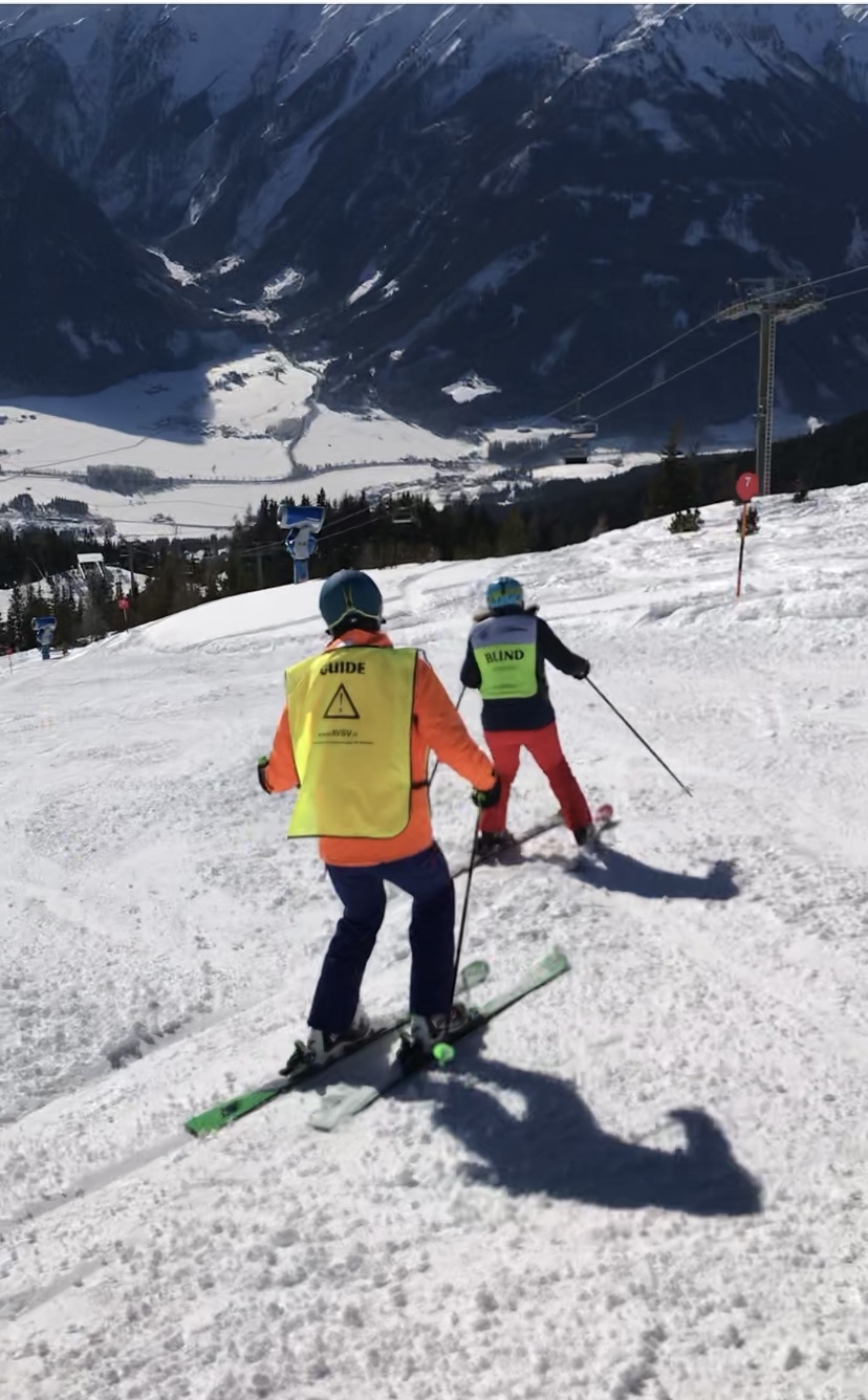 Annemiek skiënd, begeleid door een NVSV-begeleider